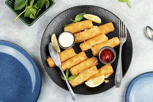 Crispy fish strips with sauce. photo