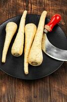 Fresh parsnip roots on wooden table. photo