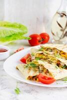 Mexican Quesadilla wrap with chicken, corn and sweet pepper on white plate. photo