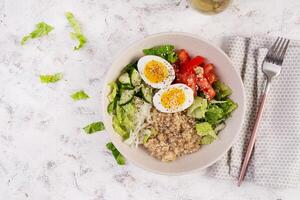 Breakfast oatmeal porridge with boiled eggs, tomato, cucumber and onions. Healthy balanced food. Trendy food. Top view, flat lay photo