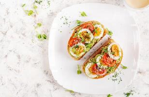 delicioso brindis con palta, hervido huevo, Tomates y microverde en un blanco lámina. sano comiendo, desayuno. ceto dieta alimento. de moda alimento. parte superior ver foto