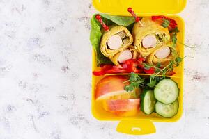 School lunch box with sausage roll in omelette with lavash. Lunchbox. Keto lunch. Top view, flat lay photo