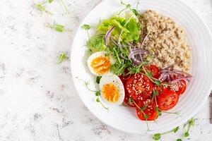 desayuno harina de avena gachas de avena con hervido huevos y Fresco vegetales. sano equilibrado alimento. de moda alimento. parte superior vista, plano laico foto