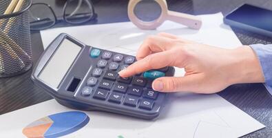 financiero gestión. mujer mano en calculadora. foto