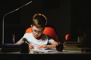 boy doing homework at home in evening photo