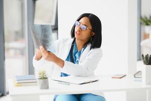 African American doctor working in her office at clinic. photo