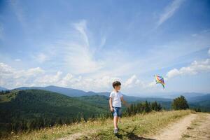 Little boy flies a kite into the blue sky photo