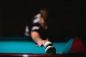 Young man playing billiard. Spending free time on gambling photo