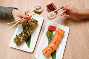 Japanese rolls on black background isolated with reflections photo