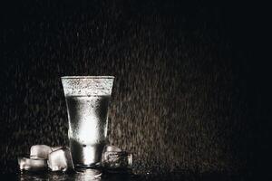 Vodka. Shots, glasses with vodka with ice .Dark background. Copy space .Selective focus. photo