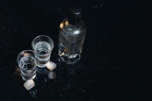 Vodka. Shots, glasses with vodka with ice .Dark background. Copy space .Selective focus. photo