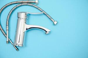 Single handle water tap on light blue background, closeup photo