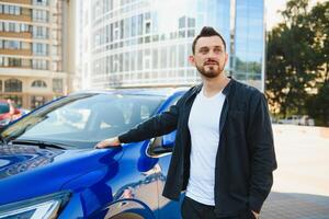 Test drive for auto. Pleasant overjoyed handsome boy holding steering wheel and driving his car while expressing gladness photo