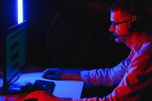 young man playing computer games on line photo