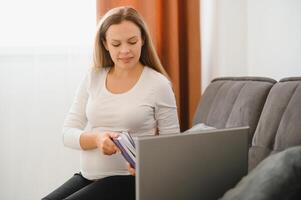 embarazada mujer vídeo chateando con médico en ordenador portátil. profesional médico en línea consulta concepto. foto