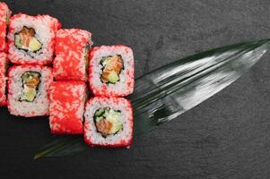 Japanese rolls on black background isolated with reflections photo