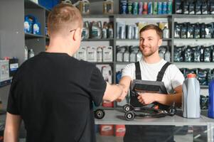 The seller selects new car repair parts for the client photo