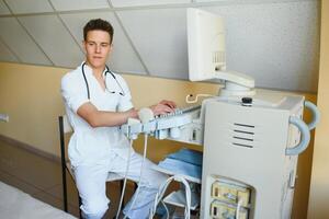 Sonographer operating modern ultrasound machine in clinic photo