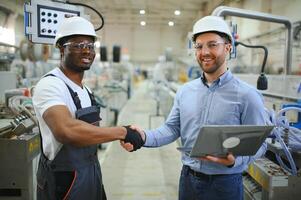 dos trabajadores a el fábrica. ingeniero y trabajador foto