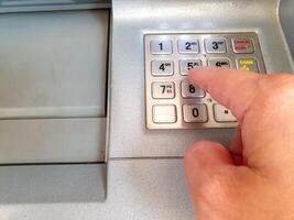 Hand of human pushing password numbers of ATM numbers keyboard. photo