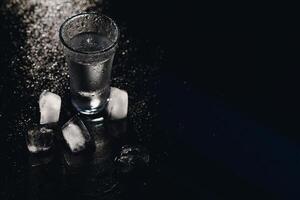 Vodka. Shots, glasses with vodka with ice .Dark background. Copy space .Selective focus. photo