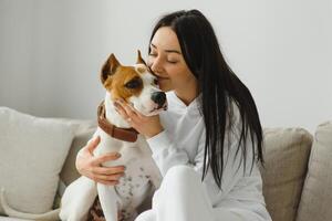 joven mujer con su linda perro a hogar. encantador mascota. foto