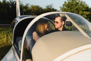 Young woman and pilot in in the cockpit of a plane. Front view photo