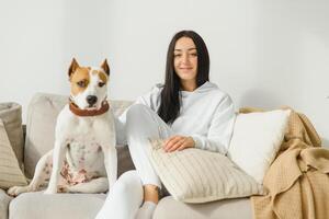 joven mujer con su linda perro a hogar. encantador mascota. foto