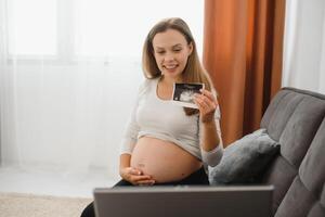 selectivo atención de alegre embarazada mujer demostración ultrasonido fotos mientras teniendo vídeo llamada