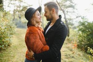 Young woman and man walking in city park holding hands. photo