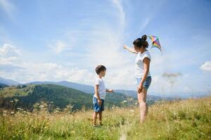 Little boy flies a kite into the blue sky photo