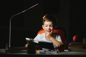 boy doing homework at home in evening photo