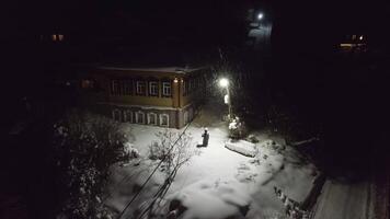 noite queda de neve dentro a Vila e uma solitário lanterna video