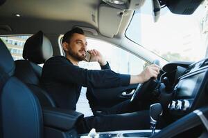 Test drive for auto. Pleasant overjoyed handsome boy holding steering wheel and driving his car while expressing gladness photo