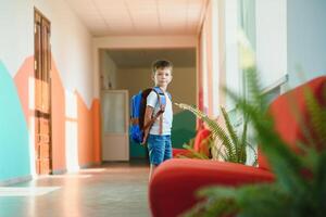 schoolboy with a backpack in the school hallway photo