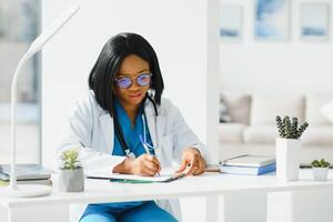 African American doctor working in her office at clinic. photo