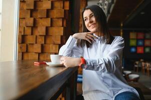 Beautiful young woman with a cup of tea at a cafe photo