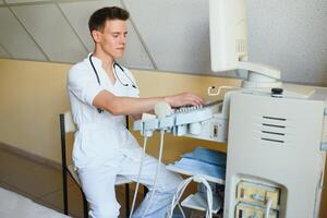 Sonographer using modern ultrasound machine in clinic photo