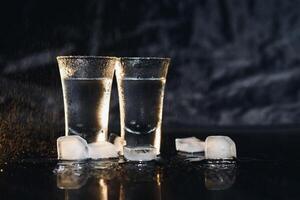 Vodka. Shots, glasses with vodka with ice .Dark background. Copy space .Selective focus. photo