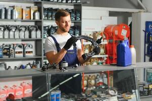 Auto parts store. The seller receives the product and evaluates the quality photo