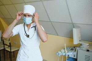 masculino médico en máscara con ultrasonido equipo en el clínica oficina foto
