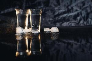 Vodka. Shots, glasses with vodka with ice .Dark background. Copy space .Selective focus. photo