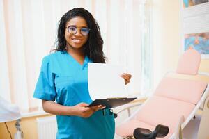 Professional female doctor on blurred consulting room background. African American gynecologist. Gynecology concept. photo