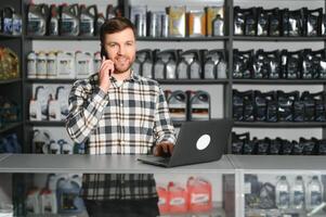 A salesman in an auto parts store is talking to a customer on the phone photo