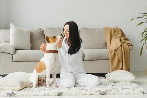 Young woman with her cute dog at home. Lovely pet. photo