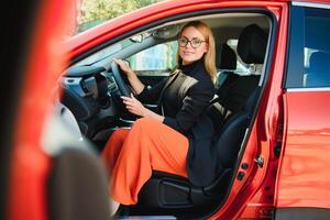 exitosa mujer de negocios conduciendo un automóvil a través de la ciudad urbana moderna con reflejos de edificios foto