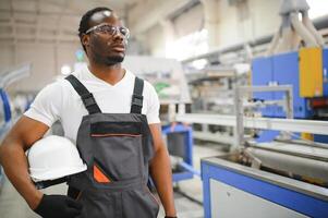 retrato de industrial ingeniero. fábrica trabajador en pie en fábrica producción línea foto