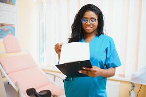 Professional female doctor on blurred consulting room background. African American gynecologist. Gynecology concept. photo