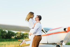 alto volador romance. frente ver de sonriente joven mujer llevar a cuestas en su novio mientras acuerdo brazos extendido. privado avión antecedentes foto