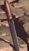 Excalibur sword in rocky stone at sunset video